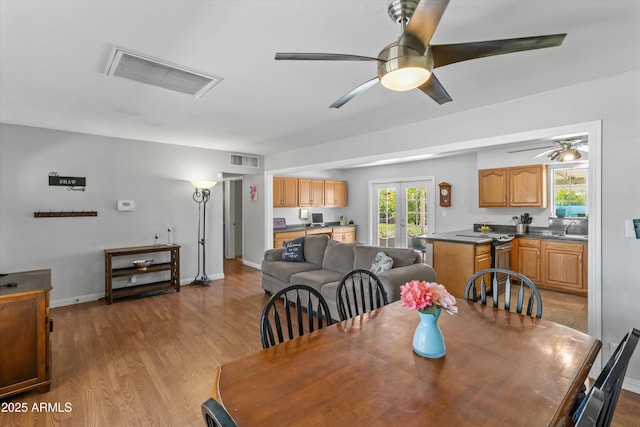 dining area featuring wood finished floors, visible vents, and ceiling fan