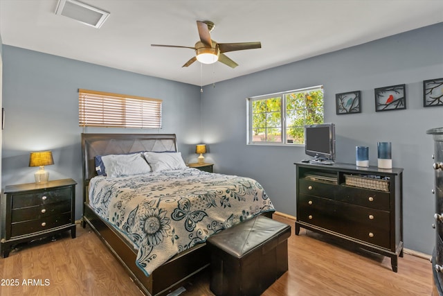 bedroom featuring wood finished floors, visible vents, and a ceiling fan