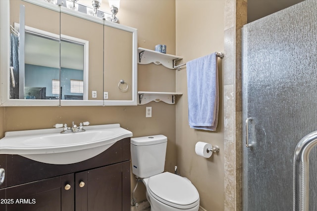 bathroom with a shower with shower door, toilet, and vanity