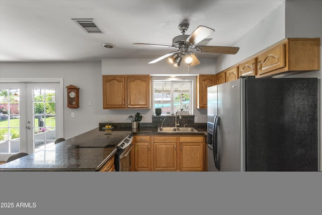 kitchen featuring a peninsula, a sink, a healthy amount of sunlight, visible vents, and appliances with stainless steel finishes
