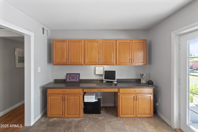 office area with built in study area, visible vents, and baseboards