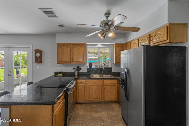kitchen featuring a sink, a wealth of natural light, electric range, a peninsula, and refrigerator with ice dispenser