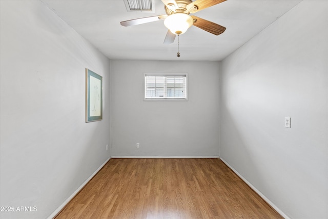 unfurnished room with baseboards, a ceiling fan, wood finished floors, and visible vents