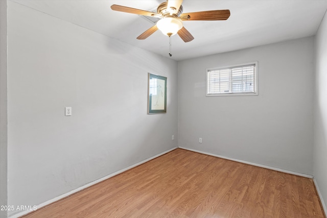 spare room with baseboards, a ceiling fan, and light wood-style flooring