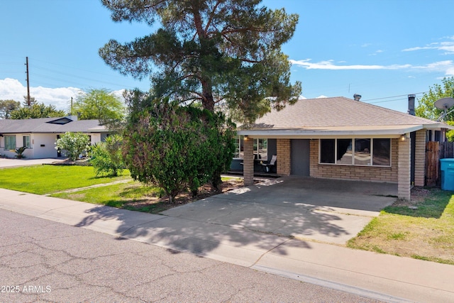 view of front of house featuring fence, a front lawn, roof with shingles, and concrete driveway