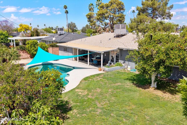 back of house featuring fence, an outdoor pool, cooling unit, a patio, and a lawn