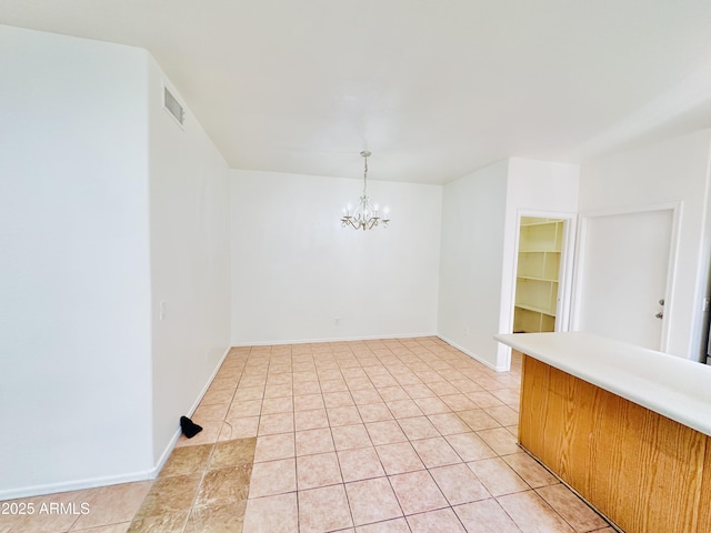 unfurnished dining area with light tile patterned floors and a notable chandelier