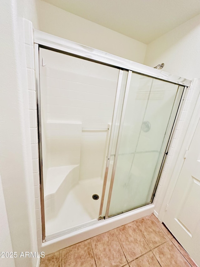 bathroom featuring tile patterned flooring and an enclosed shower