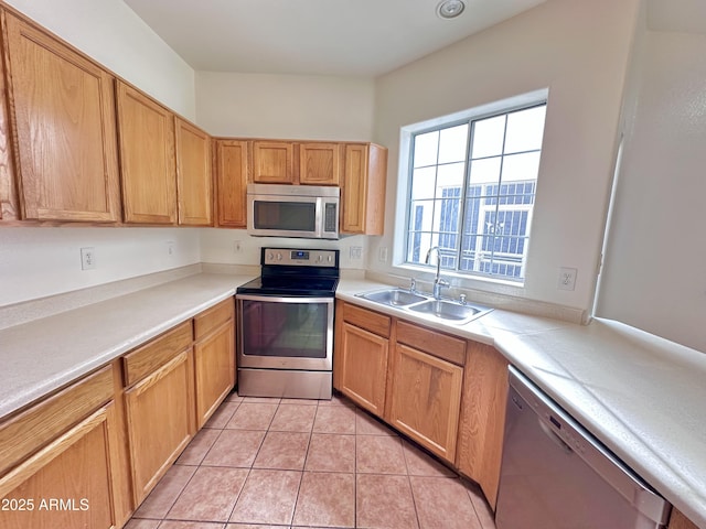 kitchen with light tile patterned flooring, appliances with stainless steel finishes, and sink