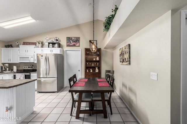 tiled dining room with vaulted ceiling