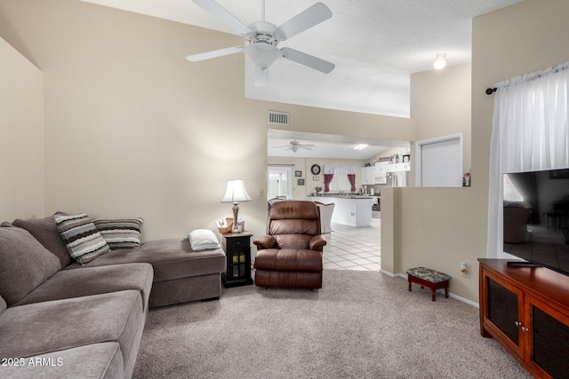 living room featuring plenty of natural light, light colored carpet, and ceiling fan