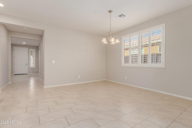 empty room featuring a notable chandelier and light tile patterned floors