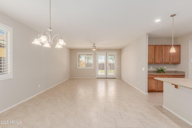 interior space featuring decorative light fixtures, light tile patterned flooring, and ceiling fan with notable chandelier