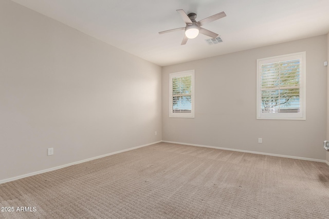 spare room featuring carpet flooring, ceiling fan, and a wealth of natural light