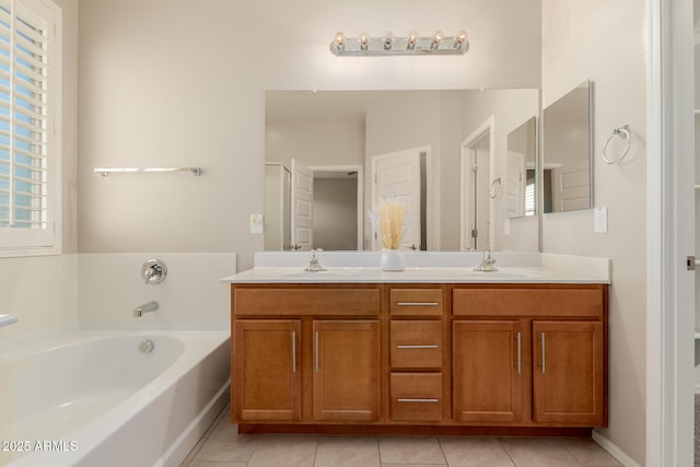 bathroom with a washtub, vanity, and tile patterned floors