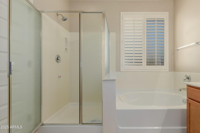 bathroom featuring vanity and independent shower and bath