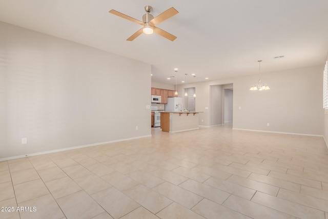 unfurnished living room with ceiling fan with notable chandelier and light tile patterned floors