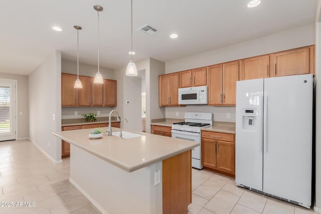 kitchen featuring white appliances, an island with sink, sink, decorative light fixtures, and light tile patterned flooring