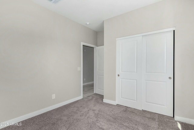 unfurnished bedroom featuring a closet, carpet flooring, visible vents, and baseboards