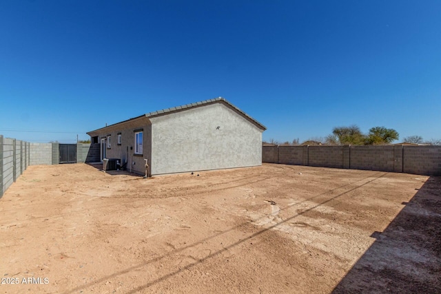 exterior space featuring central air condition unit, a fenced backyard, and stucco siding