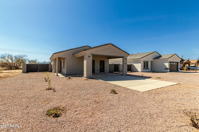 rear view of house with fence and stucco siding