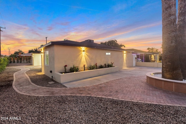 property exterior at dusk with a patio