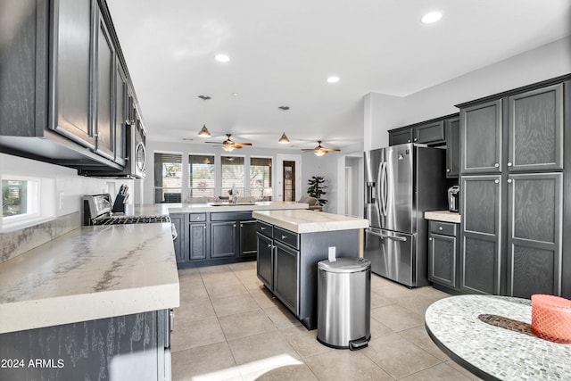 kitchen featuring hanging light fixtures, appliances with stainless steel finishes, plenty of natural light, and a center island