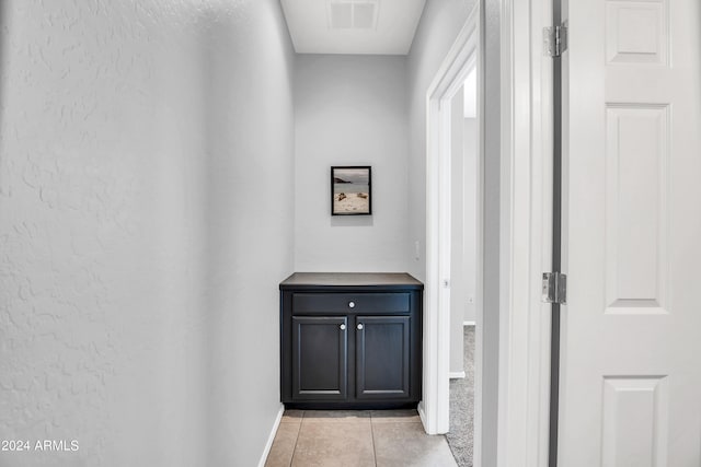 hall featuring light tile patterned floors