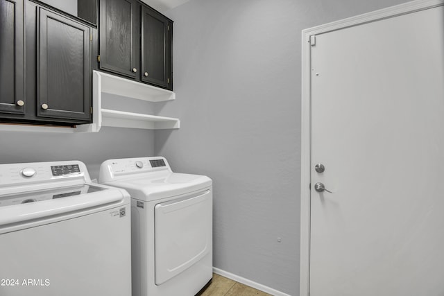 clothes washing area with washer and clothes dryer, cabinets, and light tile patterned floors