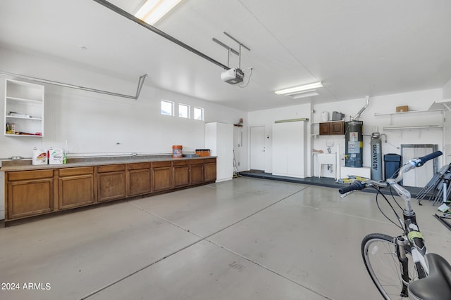 garage with gas water heater and a garage door opener