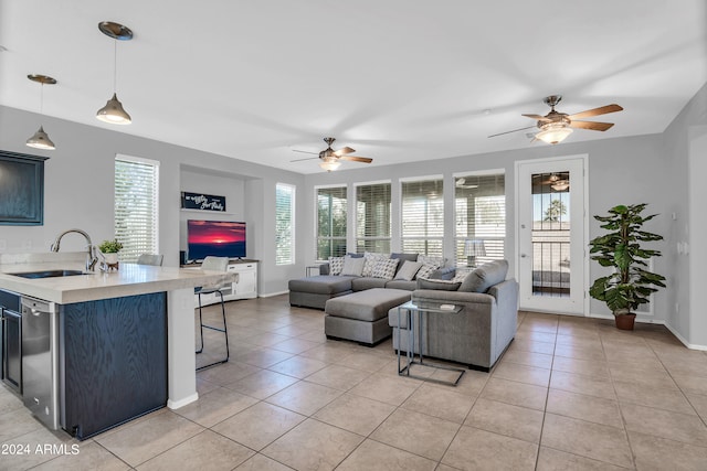 living room featuring ceiling fan, light tile patterned flooring, and sink