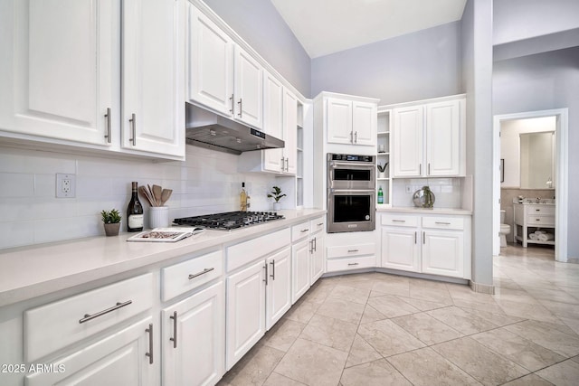 kitchen with appliances with stainless steel finishes, white cabinets, light countertops, and under cabinet range hood