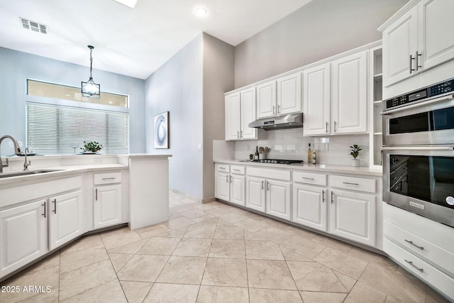 kitchen featuring stainless steel double oven, under cabinet range hood, a sink, visible vents, and light countertops