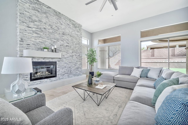 living room featuring ceiling fan and a fireplace