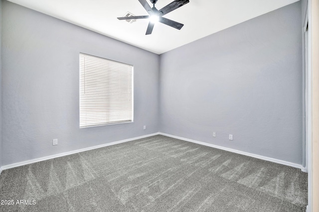 unfurnished room featuring baseboards, dark colored carpet, and a ceiling fan