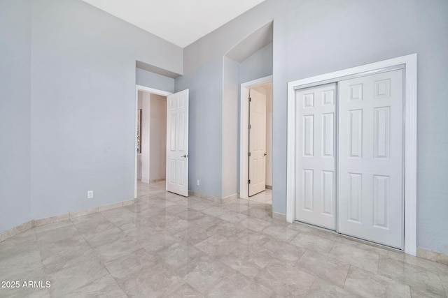 unfurnished bedroom with a closet and baseboards