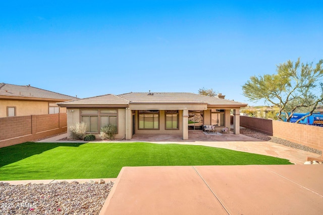 rear view of house featuring a patio, a lawn, a fenced backyard, and a tiled roof