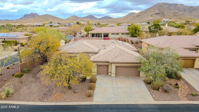 view of front of house featuring a mountain view, a tiled roof, and an attached garage