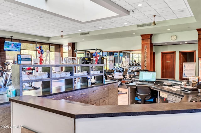 interior space with dark countertops, a drop ceiling, plenty of natural light, and visible vents