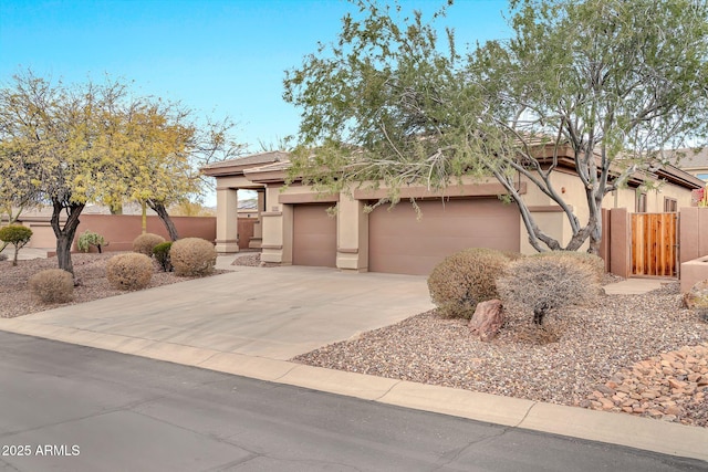 adobe home featuring driveway, an attached garage, fence, and stucco siding