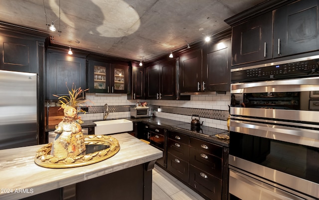 kitchen featuring sink, decorative backsplash, butcher block countertops, dark brown cabinetry, and stainless steel appliances