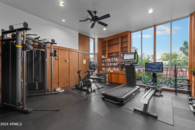 gym featuring ceiling fan and a wall of windows