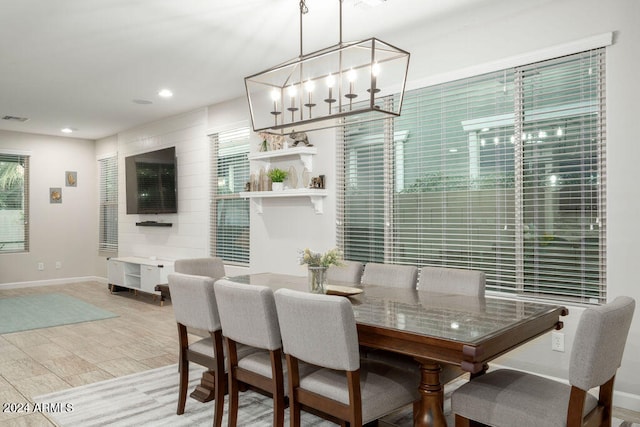 dining room with light wood-type flooring and an inviting chandelier