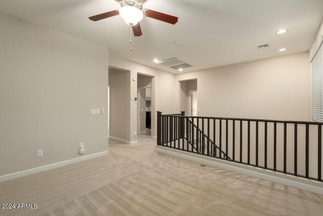 spare room featuring light carpet and ceiling fan