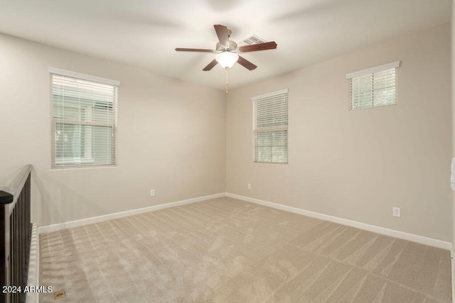 carpeted spare room featuring ceiling fan