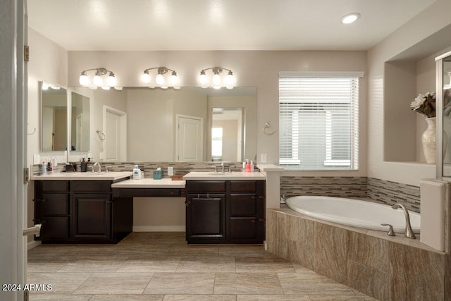 bathroom featuring vanity and a relaxing tiled tub