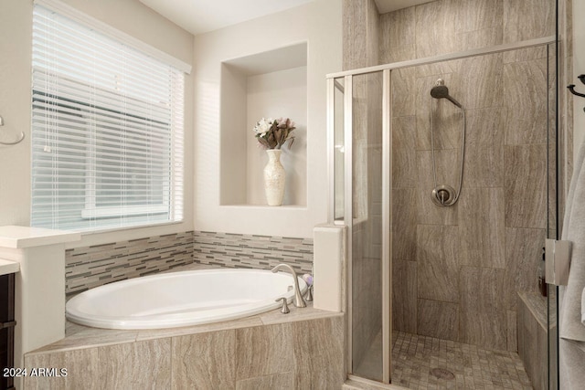 bathroom with independent shower and bath and a wealth of natural light