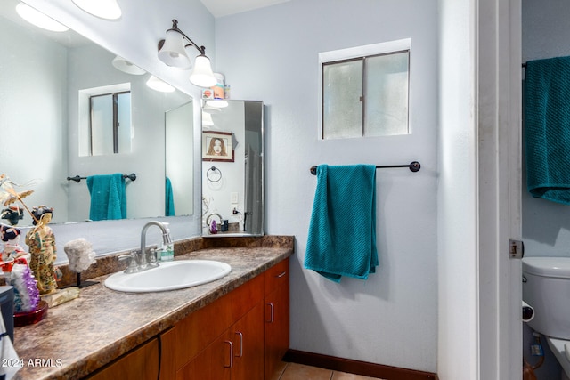 bathroom with vanity, toilet, and tile patterned floors