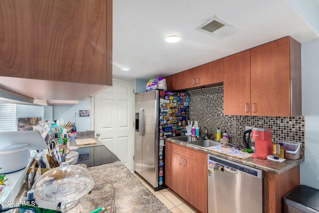 kitchen featuring light tile patterned floors, appliances with stainless steel finishes, tasteful backsplash, and sink