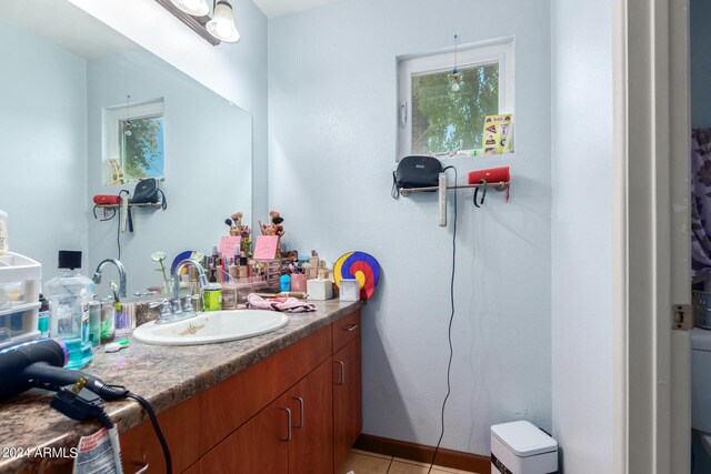 bathroom with tile patterned flooring, vanity, and toilet